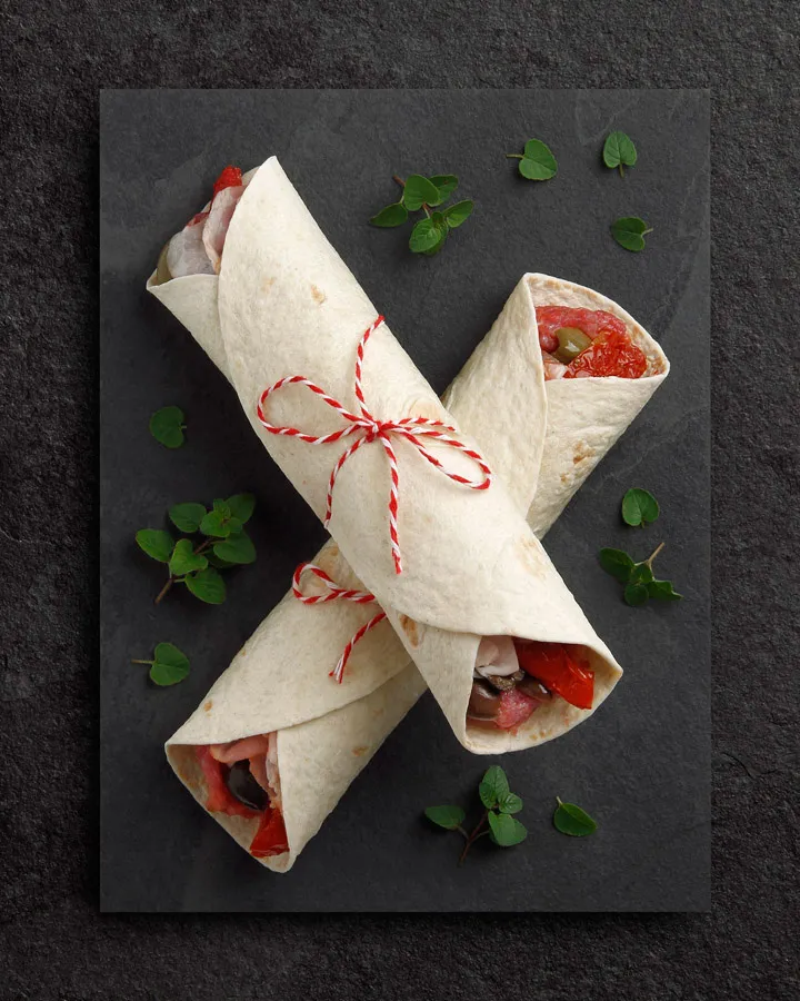 Piadina rellena de carne picada, mozzarella, bacon, tomate seco y olivas griegas. Especial horno